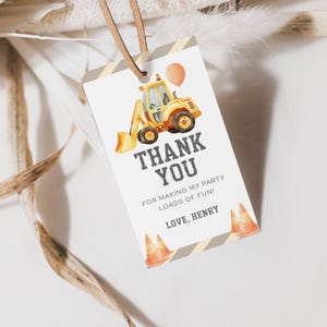 May include: A white tag with a construction theme. It features a yellow excavator, an orange balloon, and the words "THANK YOU" in bold letters. The tag also includes the text "FOR MAKING MY PARTY LOADS OF FUN! LOVE, HENRY."