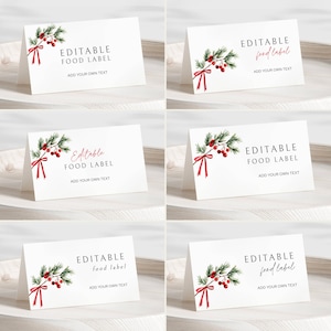 Puede incluir: Tarjetas plegadas blancas con el texto "EDITABLE FOOD LABEL" y "ADD YOUR OWN TEXT". Cada tarjeta presenta un diseño de acuarela de ramas de pino verdes, bayas rojas y una cinta roja. Las tarjetas están dispuestas sobre una superficie clara.