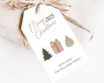 Peut inclure: Une étiquette cadeau blanche avec l'inscription "Merry 2025 Christmas" en écriture cursive. L'étiquette présente des illustrations d'un sapin de Noël, d'un cadeau emballé et d'une décoration. L'étiquette est attachée à un cadeau emballé avec un nœud en raphia.