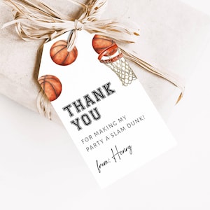May include: A white gift tag with basketball illustrations and the text "THANK YOU FOR MAKING MY PARTY A SLAM DUNK!" The tag is tied to a wrapped gift with raffia ribbon. The tag is signed "from: Henry".