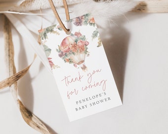 Può includere: Un'etichetta di ringraziamento bianca con un'illustrazione ad acquerello di una mongolfiera con fiori. Il testo recita "Grazie per essere venuto alla Baby Shower di Penelope".