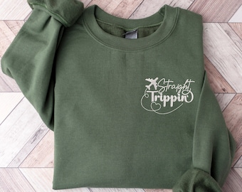 May include: A green sweatshirt with a white graphic that says "Straight Trippin'" with a small airplane icon.