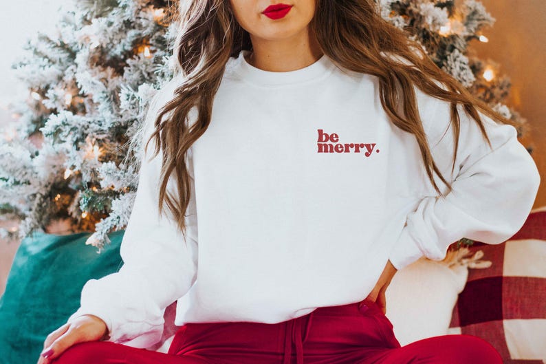 May include: White sweatshirt with red text that says "be merry."