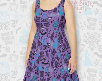 May include: A purple sleeveless dress with a print of various images and text from the Haunted Mansion attraction at Disneyland. The print includes the text "Welcome Foolish Mortals", "Beware of Hitchhiking Ghosts", and "999 Happy Haunts".