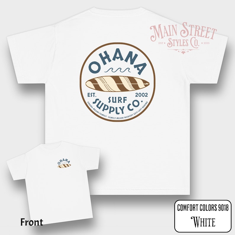 May include: White t-shirt with a circular graphic on the back that reads "OHANA SURF SUPPLY CO." with a surfboard illustration. The front of the shirt has a smaller version of the same design. The text "COMFORT COLORS 9018 White" is in the bottom right corner.