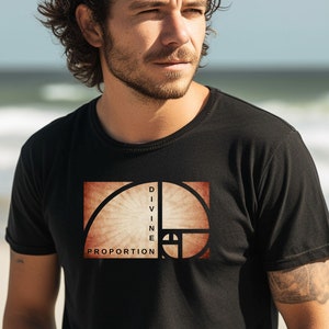 May include: Black t-shirt featuring a graphic of the golden ratio with the words "DIVINE PROPORTION" in a rectangular design. The design is in shades of brown and beige. The t-shirt is worn by a person.
