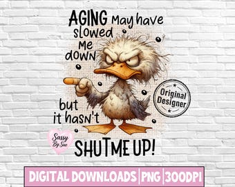 Può includere: Un design grafico digitale raffigurante un'anatra scontrosa e spettinata con becco e zampe arancioni, che indica con l'ala. Il testo recita: AGING May have slowed me down but it hasn't SHUT ME UP! Include un cuore Sassy By Sue e un timbro Original Designer.