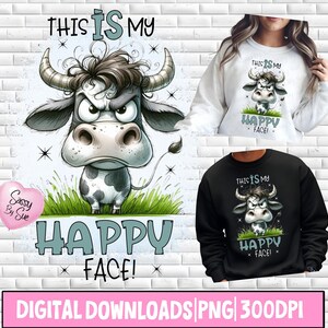 Pode incluir: Um download digital com uma ilustração de desenho animado de uma vaca zangada com o texto "THIS IS MY HAPPY FACE!". O design está em um fundo branco e também é mostrado em um moletom branco e preto.