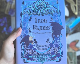 May include: A purple book with a blue and white design. The title is "Iron Flame" and the subtitle is "The Empyrean Series". The author is "Rebecca Yarros".