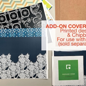 May include: Assortment of patterned paper sheets with floral, geometric, and paisley designs in navy, black, white, and blue. The text "ADD-ON COVER-KIT" and "Printed designs & Chipboard" is visible. A Square Zero cover design kit is also included.
