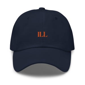 Puede incluir: Una gorra de béisbol azul marino con un "ILL" bordado en naranja en la parte delantera.