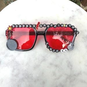Widespread Panic Sunglasses. Custom “Schools…Dropping Bombs Since ‘86”…bass bombs that is! Black square frame with red lenses.