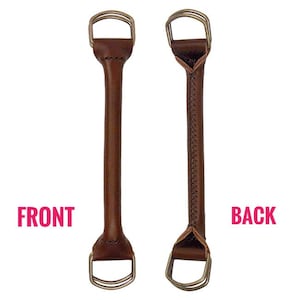 May include: Two brown leather bag handles with metallic D-rings at each end. The left handle shows a smooth front surface, while the right handle displays the back side with visible stitching along the center and reinforced triangular leather tabs.