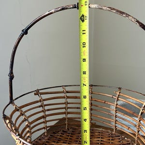 May include: A brown wicker basket with a metal handle. The basket is 12 inches tall.