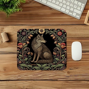 May include: Black rectangular mousepad featuring a detailed illustration of a wolf in a floral frame. The wolf is brown and gray, set against a black background. The floral border includes orange, red, and green elements.