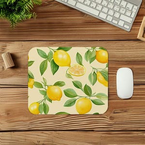 May include: A rectangular mousepad with a lemon and leaf pattern. The design features yellow lemons and green leaves on a light yellow background. A computer mouse and keyboard are visible in the background.
