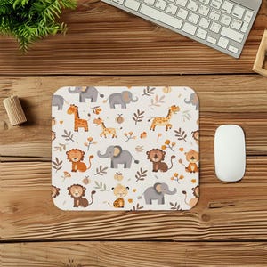 May include: A square mousepad with a cream background featuring a repeating pattern of cartoon animals, including elephants, giraffes, and lions. The design incorporates brown, orange, and gray elements, with floral accents. A white mouse and keyboard are visible.