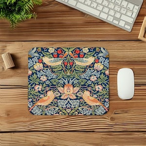 May include: A rectangular mousepad with a detailed floral and bird design. The pattern features birds, strawberries, and flowers in shades of orange, pink, green, and cream against a dark blue background. The mousepad is on a wooden desk with a keyboard and mouse.