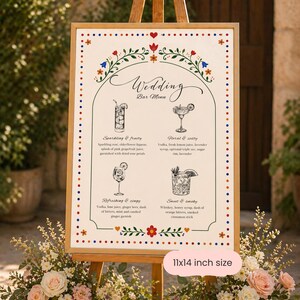Whimsical floral wedding bar menu sign with colorful folk art border and illustrated drinks, editable Canva template displayed on easel and table settings