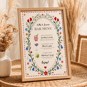 Whimsical floral wedding bar menu sign with colorful folk art border and illustrated drinks, editable Canva template displayed on easel and table settings