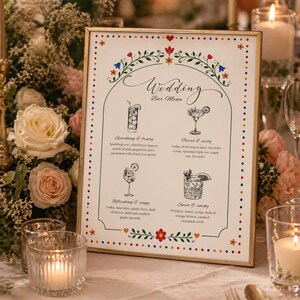 Whimsical floral wedding bar menu sign with colorful folk art border and illustrated drinks, editable Canva template displayed on easel and table settings