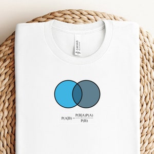 May include: White t-shirt with a blue and gray Venn diagram and the formula "P(A|B) = P(B|A)P(A) / P(B)" printed on the front.
