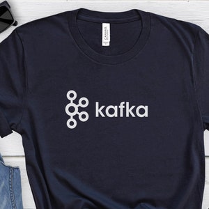 May include: A navy blue t-shirt with a white graphic of the Kafka logo and the word "kafka" in white text.