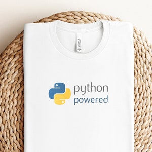 May include: White t-shirt with a blue and yellow Python logo and the text "python powered".