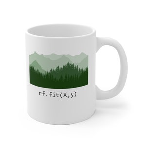 May include: White ceramic mug with a green mountain and forest silhouette and the text "rf.fit(X,y)" printed on the front.