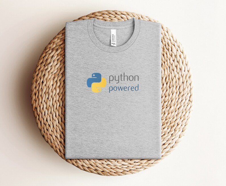 Peut inclure: Un t-shirt gris avec un logo Python bleu et jaune et le texte "python powered".