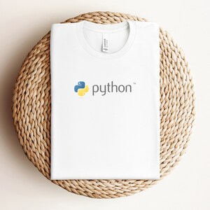 Peut inclure: T-shirt blanc avec un logo Python bleu et jaune et le mot "python" en gris.