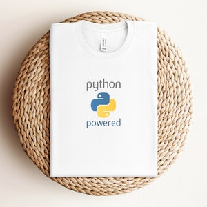 Pode incluir: Camiseta branca com o texto "python powered" e um logotipo de pit&atilde;o amarelo e azul.