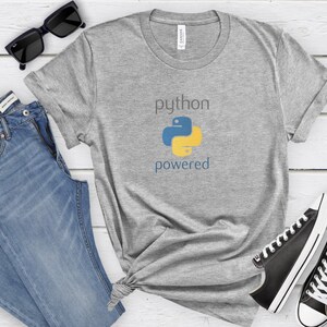 Pode incluir: Uma camiseta cinza com o texto "python powered" e um logotipo de python amarelo e azul.