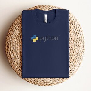Peut inclure: Un t-shirt bleu marine avec un logo Python jaune et bleu et le mot "python" en gris.