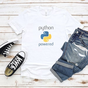 Pode incluir: Camiseta branca com o texto "python powered" e um logotipo de pit&atilde;o azul e amarelo.