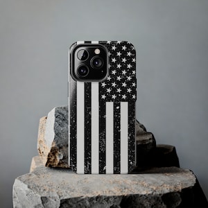 May include: A black and white distressed American flag phone case for an iPhone.