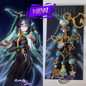 May include: A colourful charm keychain with a gold chain and various beads, including a green cloud, a gold star, and a green and gold flower. The keychain is labelled "Xianyun" and "Made By Luna".