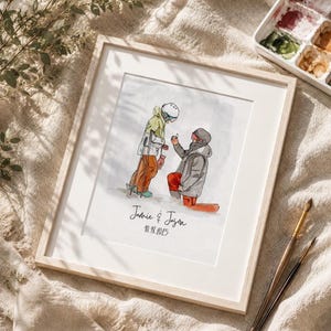 May include: Framed watercolour illustration showing a proposal scene on a snowy mountain. Two figures in ski gear are depicted. The text "Jamie & Jason" and the date "10.18.2025" are written below the figures, all within a light wood frame.