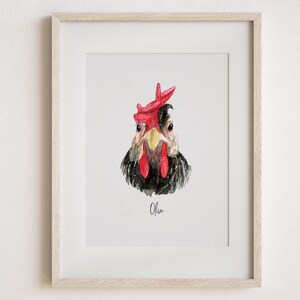 Pu&ograve; includere: Dipinto ad acquerello di un pollo bianco e nero con cresta e bargigli rossi. Il pollo guarda direttamente lo spettatore. Il dipinto &egrave; incorniciato in una cornice di legno chiaro e ha il nome "Olive" scritto sotto l'immagine.