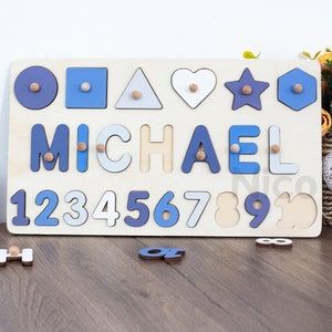 May include: Wooden puzzle board with blue and white painted shapes, letters, and numbers. The name "MICHAEL" is spelled out in blue and white letters. The numbers 1 through 10 are also included.