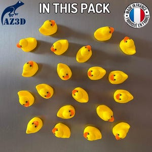 Puede incluir: Una colecci&oacute;n de veinte patitos de goma amarillos dispuestos sobre una superficie. Cada pato presenta un cuerpo amarillo brillante y un pico naranja. El texto IN THIS PACK aparece en la parte superior, junto a un logo AZ3D y una etiqueta MADE IN FRANCE.