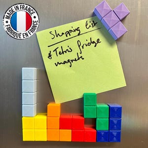 May include: Colorful Tetris-shaped fridge magnets in yellow, orange, red, green, blue, and purple. A yellow sticky note reads "Shopping list of Tetris fridge magnets". A "Made in France" sticker is in the upper left corner.