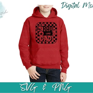 May include: A red hooded sweatshirt with a front pocket and the words "RAD LIKE DAD" in a black and white graphic. The design includes sunglasses, a thumbs-up, and a lightning bolt. The model is wearing blue jeans.