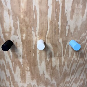 Peut inclure: Trois boutons ronds en bois de couleur noire, blanche et bleu clair.