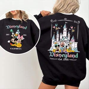Puede incluir: Sudadera negra con cuello blanco con un gr&aacute;fico de Disneyland. El gr&aacute;fico frontal incluye a Mickey Mouse, el Pato Donald y Minnie Mouse. El gr&aacute;fico trasero muestra el castillo de Disneyland y m&aacute;s personajes.