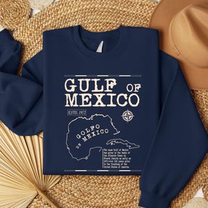 May include: Navy blue sweatshirt with a vintage-style graphic of the Gulf of Mexico. The graphic includes the text "Gulf of Mexico", "Est. 1972", "Golfo de Mexico", and a compass.