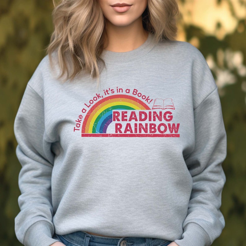 May include: A gray sweatshirt with a rainbow and the text "Take a look, it's in a book! Reading Rainbow" in red.