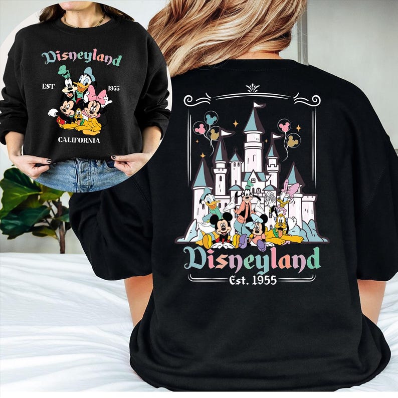 Puede incluir: Sudadera negra con dise&ntilde;o de Disneyland. La parte delantera muestra a Mickey, Minnie, Donald y Daisy Duck con "Disneyland Est. 1955 California." La parte trasera presenta un castillo y personajes con "Disneyland Est. 1955."
