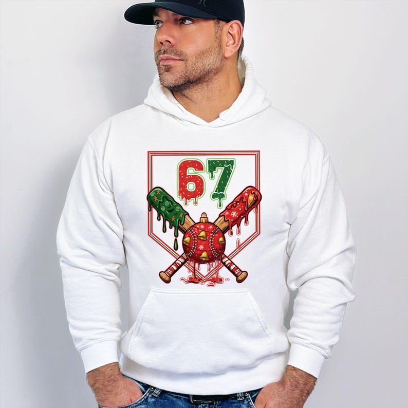 May include: White hoodie with a graphic featuring crossed baseball bats, a baseball, and the number 67 in red and green. The bats are decorated with red and green accents. The design is set against a white background.