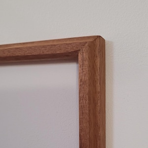 Peut inclure: Gros plan sur un coin d'un cadre photo en bois. Le cadre est en bois brun clair avec une finition lisse.